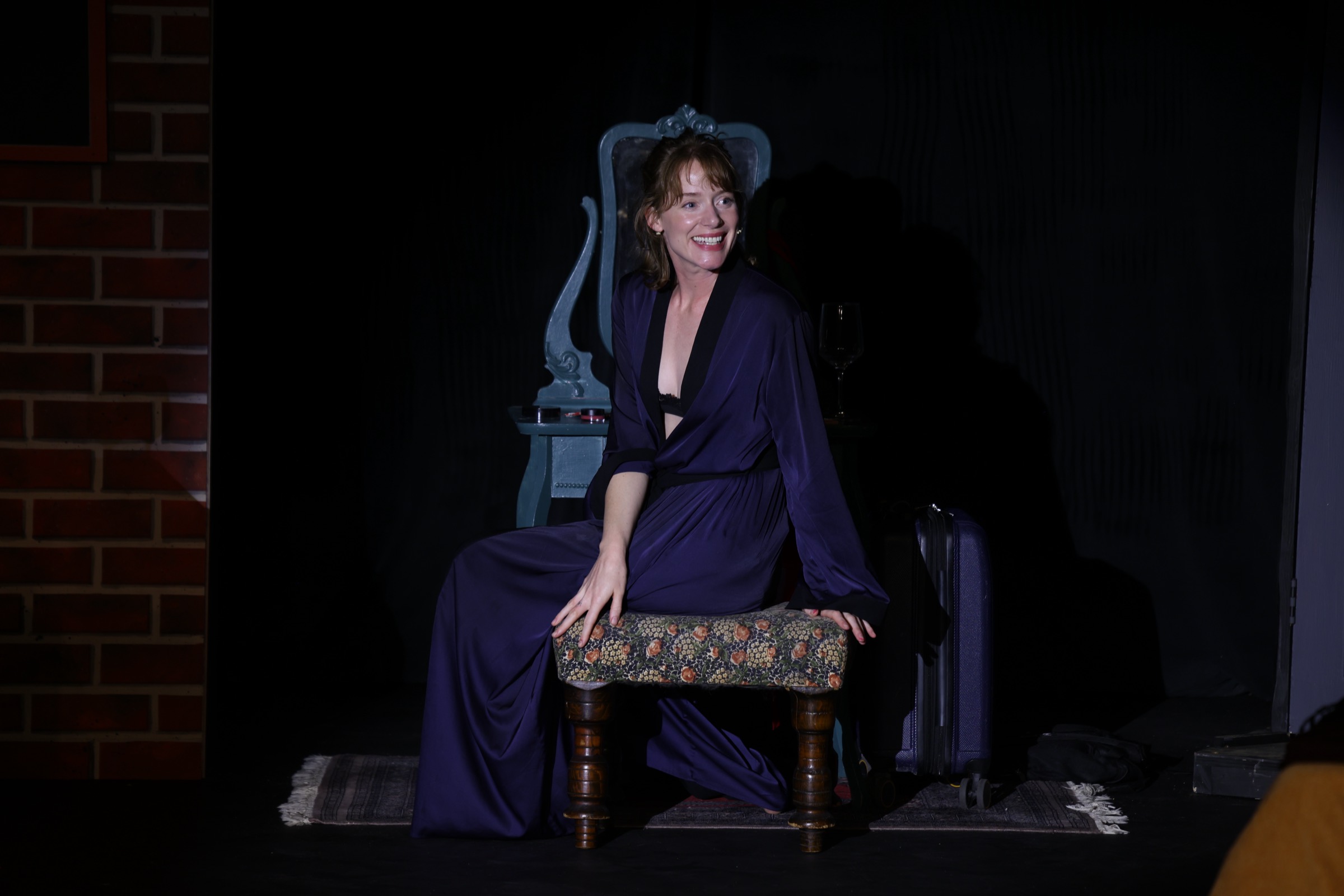 Eloise seated on a bench in a dark coat
